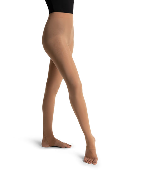 Dancer wearing tan stirrup tights on a white background 