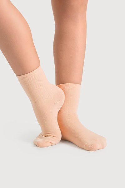Salmon pink socks worn by a person on a light gray background