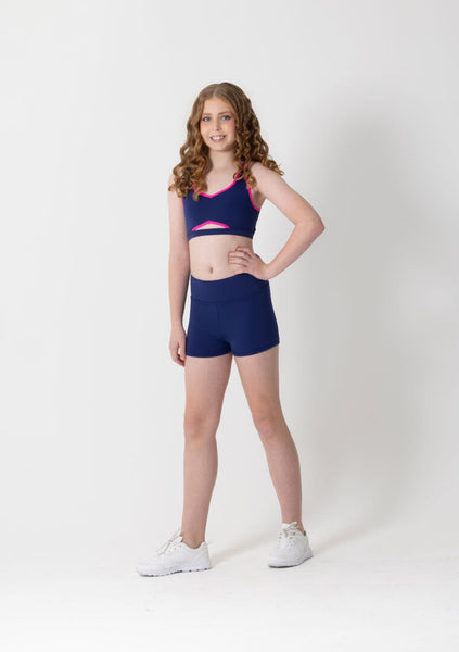 Young girl wearing a blue sports outfit with pink accents on a white background