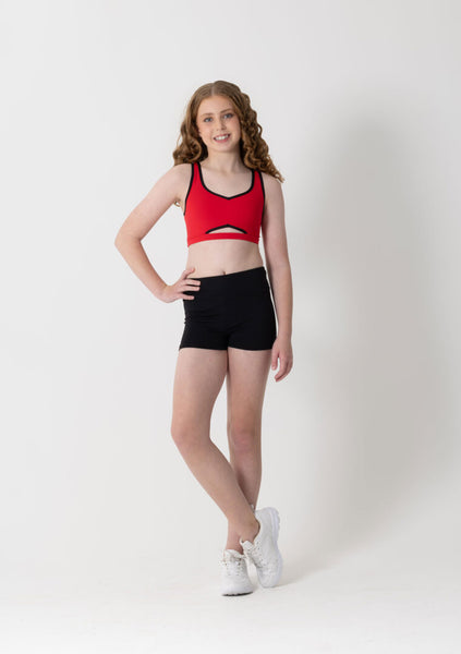 Person wearing a red sports bra and black shorts on a white background