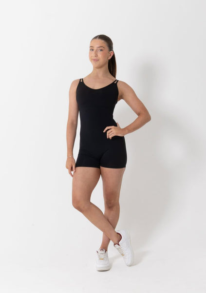Dancer wearing a black biketard on a white background