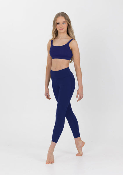 Woman wearing a navy blue athletic outfit on a white background