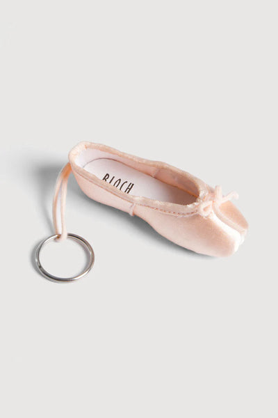 Pink ballet shoe keychain on a light gray background