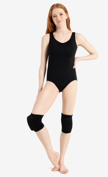 A woman modeling a black sleeveless athletic bodysuit with matching black knee sleeves against a plain light gray studio background.