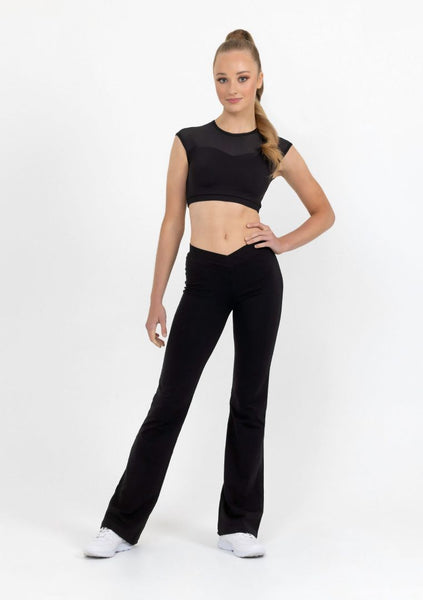 A child model wearing black jazz pants and a matching black crop top, posing against a white background.