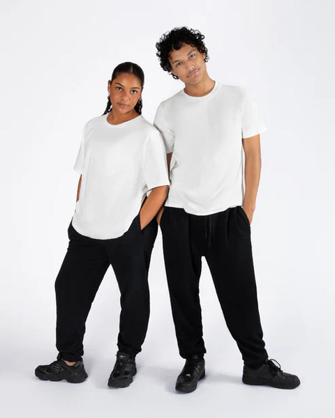 Two people wearing white t-shirts and black pants on a white background