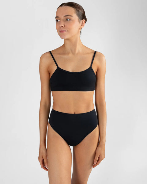 Person wearing a black sports bra and brief set on a white background