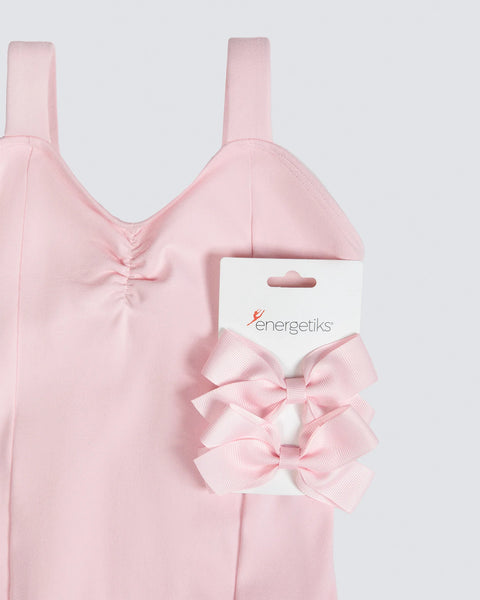 Pink leotard with matching hair bows on a white background