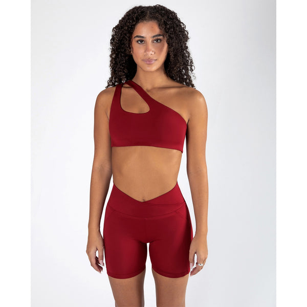 Woman wearing a red sports bra and shorts set on a white background activewear