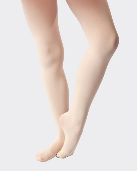 A pair of flesh-colored footed tights worn by a child, designed for ballet or dance.